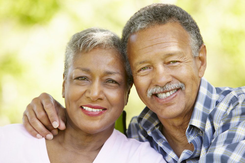 Couple with white straight teeth smiling outdoors